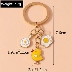Detailed view of alloy keychain with fried egg in a pan and yellow chick charms