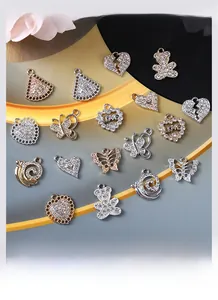 Close-up of gold-plated alloy pendants with rhinestones in bear and heart shapes