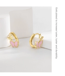 Macro shot of S925 silver gold-plated butterfly earrings with pink enamel detail