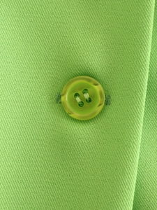 Macro shot of bright green woven fabric texture and matching resin button details