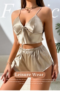 Detail of champagne satin sleepwear set featuring V-neck camisole with bow and elastic shorts