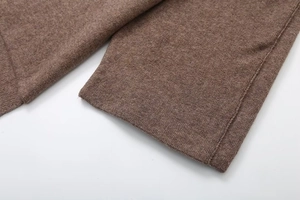 Dettaglio macro del tessuto a maglia marrone con cuciture rifinite e trama fine