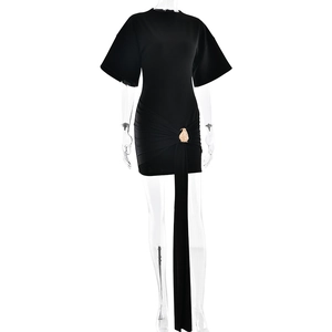 Detail of black mini dress featuring waist ruched design and a golden bird buckle