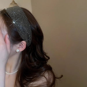 Detailed close-up showing the dense rhinestone texture of a wide fashion headband