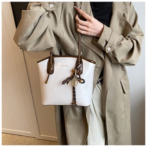 Détail du sac cabas Chrisbella avec poignées marron et pendentif raquette de tennis doré