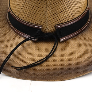 Macro detail of hand-woven straw cowboy hat with embroidered band and contrast stitching