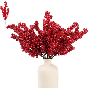 Detailed close-up of vibrant red artificial holly berries in a minimalist white ceramic vase