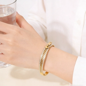 Macro detail of gold-plated stainless steel zipper bracelet with sparkling cubic zirconia