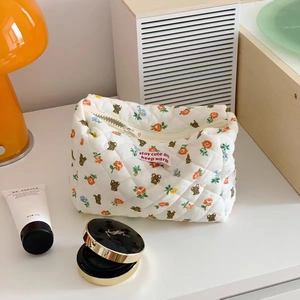 Close-up of floral bear pattern on white quilted cotton cosmetic storage bag