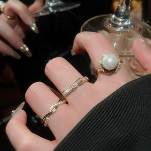 Detailed view of elegant gold-plated rings set with pearls and sparkling zircon stones