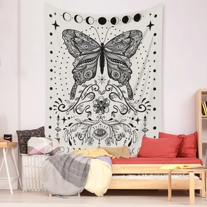 Bohemian butterfly tapestry with moon phases hanging over a cozy wooden sofa bed