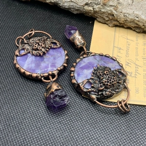Macro shot of vintage bronze lion earrings with purple crystal pendants and stone inlays