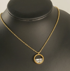 Detail of 18K gold-plated stainless steel necklace with transparent zircon pendant on mannequin