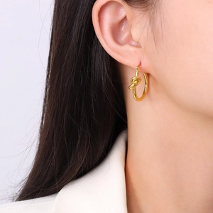 Polished gold knot hoop earrings for women featuring a minimalist metallic design