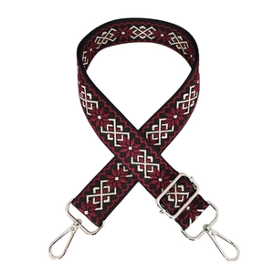 Dettaglio della tracolla jacquard boho con motivi geometrici rossi e moschettoni in metallo