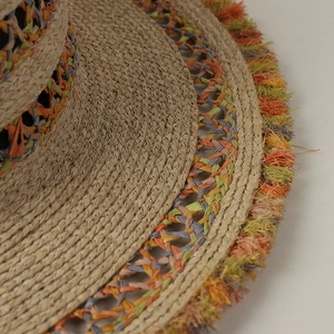 Dettaglio macro di cappello in rafia boho con frange colorate e trama di tessitura cava