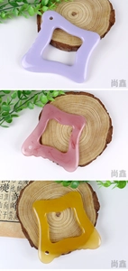 Three colors of resin gua sha scrapers with ergonomic grip on natural wood base