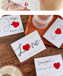 Close-up of 3D heart greeting cards with envelopes on a rustic wooden desk