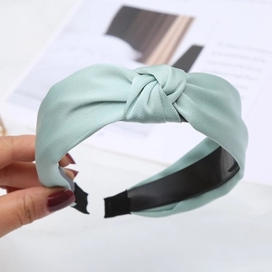 Pale green satin knotted headband with a wide non-slip design and soft silky texture
