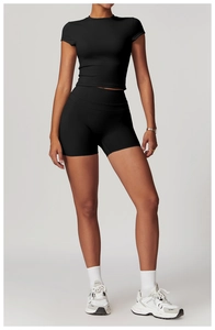 Dettaglio del set yoga nero con crop top e pantaloncini a vita alta indossato dal modello