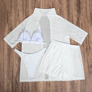 Flat lay of a white four-piece mesh beach set with bikini and matching cover-ups