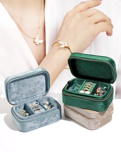 Three velvet jewelry boxes in green blue and beige with zipper closure and interior slots