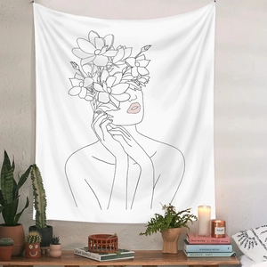 Close-up of minimalist line art tapestry featuring floral woman face on white wall