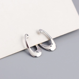 Macro detail of irregular S925 silver hoop earrings with a sleek metallic finish