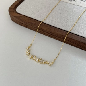 Detail of gold necklace with marquise and round cubic zirconia in olive branch design