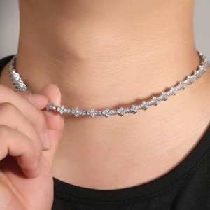 Dettaglio della collana tennis argento con pietre CZ floreali sul collo di un uomo