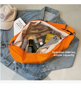 Detailed view of spacious orange crossbody bag interior with zipper pockets and daily items