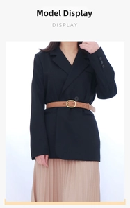 Brown suede belt with gold buckle styled over a black blazer and pleated skirt