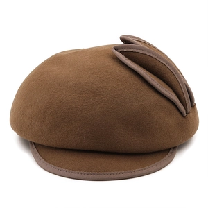 Detail of a brown wool felt baseball cap featuring unique pleated decorative ears