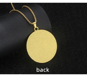 Macro detail of the gold-plated round pendant back featuring a textured grid pattern