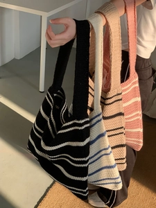 Minimalist knitted striped tote bags in four colors shown in a natural sunlight setting