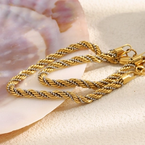 Detail of twisted gold rope chain with silver beads on an iridescent shell display