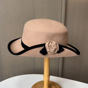 Détail d'un chapeau en feutre de laine camel avec bordure en velours noir et rose