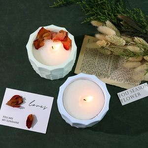 Detailed view of ceramic scented candles with geometric design and dried flower petals