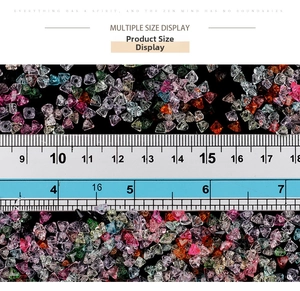 Macro view of gradient crystal glass triangle beads with size ruler on black background