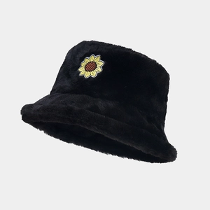 Close-up of fluffy black faux fur bucket hat with yellow sunflower embroidery patch
