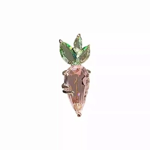 Exquisite carrot brooch featuring pink crystal stone and green gemstone leaves in gold