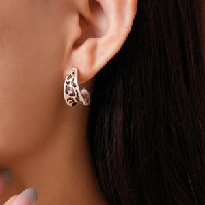Close-up of C-shaped silver leopard print earring with vintage oil-dripping texture