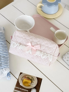 Close-up of pink gingham makeup bag featuring heart quilting and white lace trim