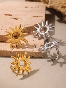 Detailed shot of gold and silver sunburst rings on a textured stone display