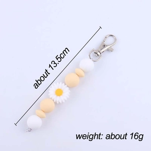 Daisy silicone beaded keychain with white and yellow beads and silver lobster clasp