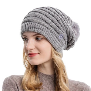 Bonnet d'hiver en tricot gris pour femme avec boutons latéraux et pompon en fausse fourrure