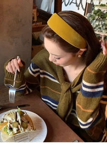 Close-up of ginger yellow velvet headband worn by model with autumn knitwear