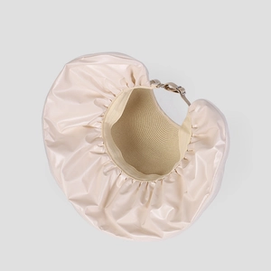 Detail of cream organza sun hat with woven interior texture and adjustable gold buckle