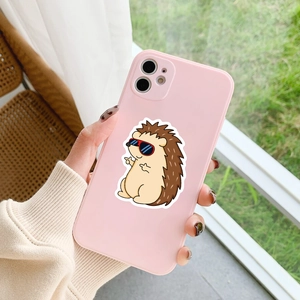 Pink iPhone case with cute cartoon hedgehog in sunglasses held against garden background