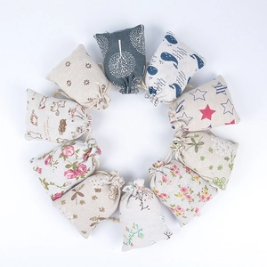 Assorted patterned cotton linen drawstring pouches arranged in a circle on white background